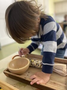 Child concentrating on a task involving a bowl