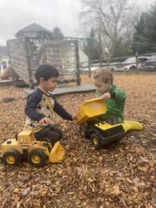Kids playing with toy dump trucks on a playground