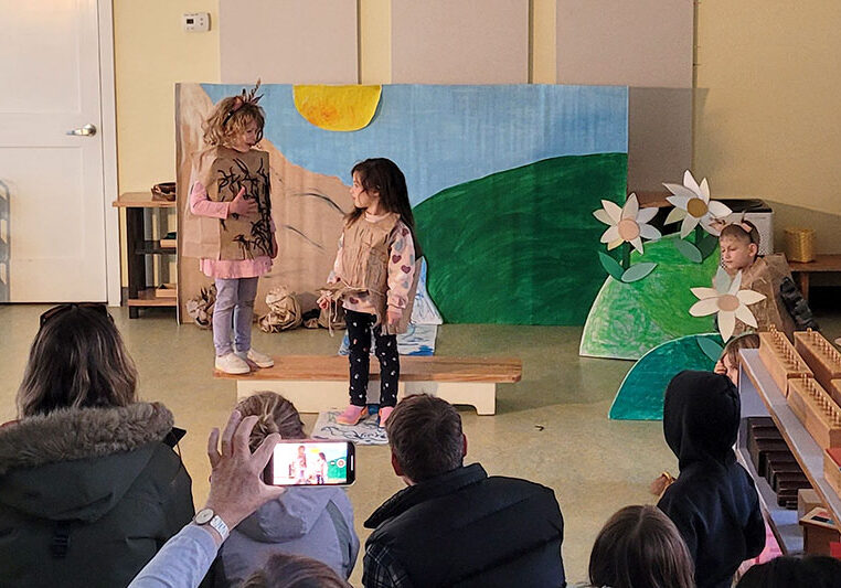 Two preschoolers performing a play for an audience of parents